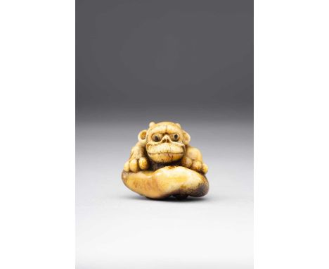 A JAPANESE STAG-ANTLER NETSUKE OF AN ONI20TH CENTURY The gargoyle-like demon depicted seated with its front paws resting on i
