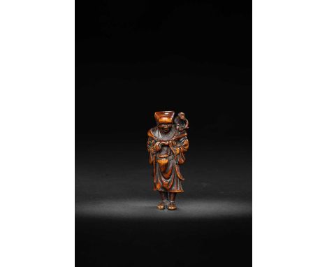 A JAPANESE WOOD NETSUKE OF A SARUMAWASHIEDO/MEIJI, 18TH/19TH CENTURYThe monkey trainer depicted standing with his small pet o