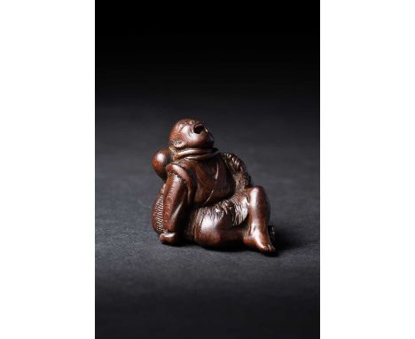 A JAPANESE PRUNUS WOOD NETSUKE OF A FISHERMAN AND OCTOPUSMEIJI ERA, 19TH CENTURY The seated man depicted with his mouth wide 