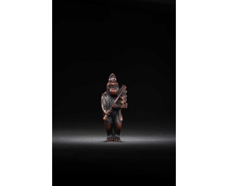 A JAPANESE WOOD NETSUKE OF A MONKEY DRESSED AS A SHINTO PRIESTMEIJI ERA, 19TH CENTURY Depicted standing, wearing an eboshi ha