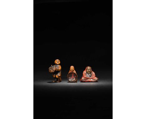 THREE JAPANESE NETSUKE MEIJI ERA, 19TH CENTURY  The first a red and black negoro lacquer netsuke of a seated Daruma looking d