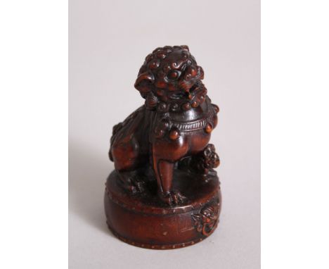 A GOOD JAPANESE MEIJI PERIOD WOODEN NETSUKE OF A SHI SHI DOG, very well carved and seated upon a drum with carved mytical fac