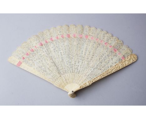 A GOOD 19TH CENTURY CHINESE CANTON CARVED IVORY FAN, with carved and pierced openwork depicting figures and shrines amongst n