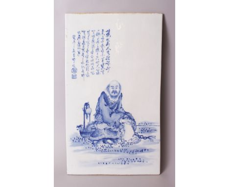 A LARGE CHINESE BLUE &amp; WHITE PORCELAIN PAINTED TILE, depicting a bearded seated elder or sage with his basket of fruit an