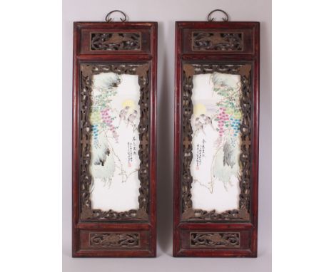 A PAIR OF CHINESE PAINTED PORCELAIN PANELS IN HARDWOOD FRAMES, each panel depicting tranquil scenes of birds sat amongst tree