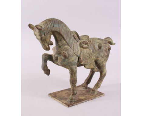 A GOOD EARLY CHINESE MING DYNASTY PATINATED  BRONZE MODEL OF A PARADE HORSE, stood upon an formed slab base, with one hoof al