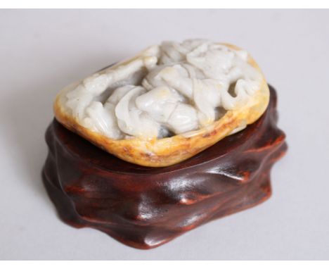 A 19th/20th CENTURY CHINESE JADE PEBBLE CARVING OF A WARRIOR, coupled with its hardwood fitted stand, 7cm x 5 cm.