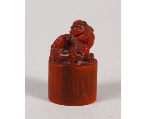 AN EARLY 20TH CENTURY CHINESE HORN SEAL, well carved with a Buddhistic lion and pup on an oval-section plinth, 6.4cm high.