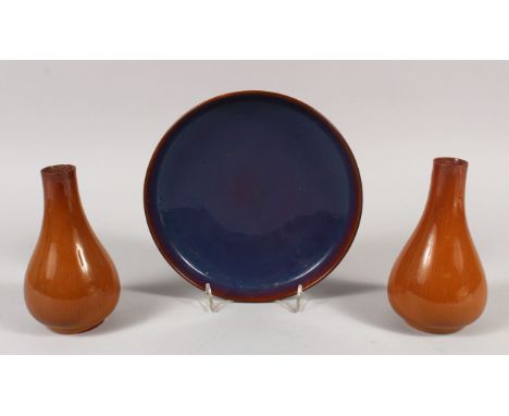A CHINESE FLAMBE STYLE CERAMIC DISH, 8in diameter; together with a pair of brown glazed pear-form vases, 14.6cm high. (3)