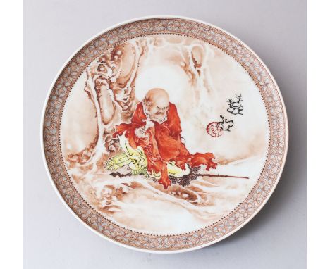 A CHINESE REPUBLICAN STYLE ENAMELLED PORCELAIN DISH, depicting scenes of a luohan resting under a tree, the right of the dish