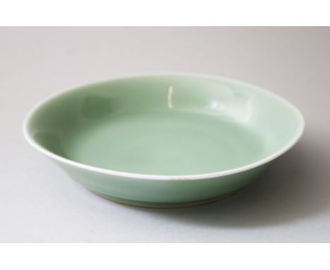 A CHINESE CELADON GLAZED DISH DAOGUANG SEAL MARK &amp; PERIOD, with a flared side and a wedge foot, with a green celadon glaz