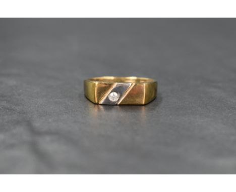 A 9ct gold signet style ring, the horizontal yellow gold panel set with a diagonal white gold band and a round cut clear past