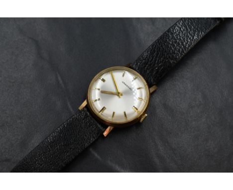 A gent's 1970's 9ct gold wrist watch by Garrard having a baton numeral dial on a pearlised face in a gold case bearing presen