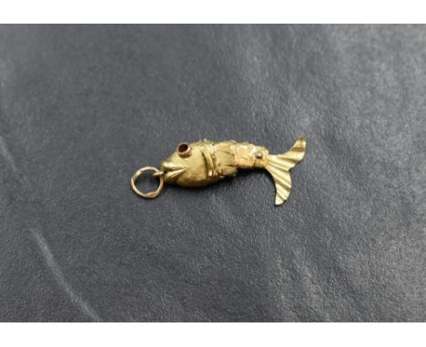 A small yellow metal articulated fish pendant having ruby style eyes, marks worn but possibly 14ct or 18ct gold approx 0.8g t