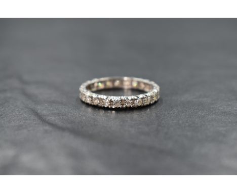 A high carat white gold diamond eternity band, having round cut illusion set diamonds to the entire band, ring size P, 3g