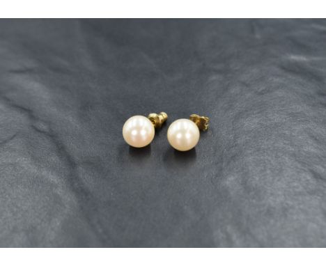 A pair of Christian Dior pearl stud earrings, the imitation pearls on yellow metal posts, 2.1g