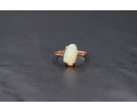 A 9ct rose gold opal ring having an asymmetrical opal cabouchon stone in a 4 claw set mount to shaped shoulders, size P &amp;