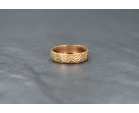A 9ct gold band, having decorative engraving and bead thread, ring size P, 1.8g