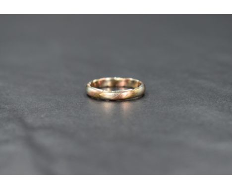 A 9ct gold three tone ring, having twisted bands of yellow, white and rose gold, ring size G-H, 1.6g