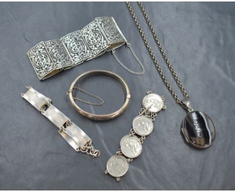 A small selection of silver jewellery, comprising a hinged bangle and three bracelets, along with a banded agate locket, 109.