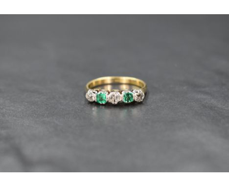An 18ct gold emerald and diamond half eternity band, the three old cut diamond interspersed with two emerald cut emeralds, ri