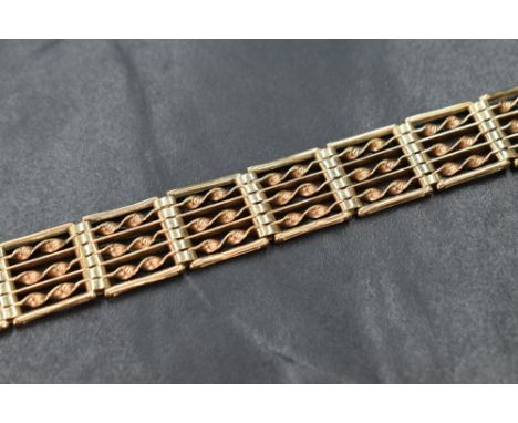 A 9ct gold seven bar gate bracelet having twist bar decoration and a padlock clasp, approx 185mm &amp; 19g