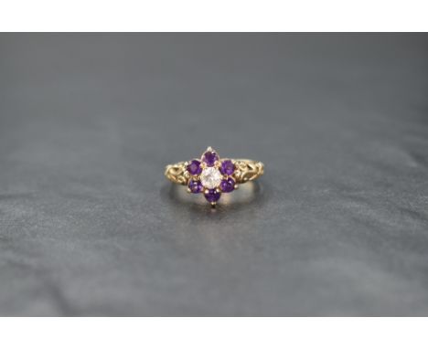 A 9ct gold white sapphire and amethyst cluster ring, the central round cut white sapphire with a six round cut amethyst surro