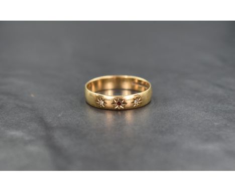A 9ct gold wedding band having inset ruby flanked by two diamond chips in star settings, size V &amp; approx 32g