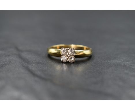 An 18ct gold four stone diamond square set ring having a central diamond chip, total approx 0.5ct, all in a claw set mount to