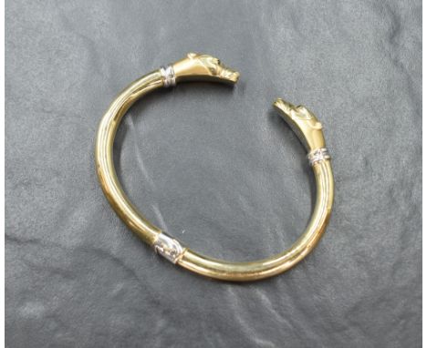A white and yellow metal panther head hinged bangle stamped 585 having moulded panther head terminals with onyx set eyes, int