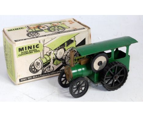 A Triang Minic tinplate and clockwork model of a traction engine comprising of green body with black plastic wheels, in the o