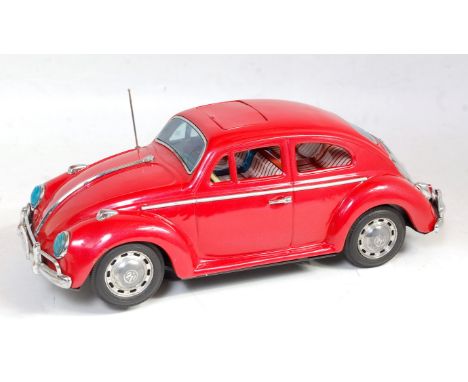A 1950s Bandai tinplate and battery operated model of a king size Volkswagen Sedan comprising of red body with detailed tinpr