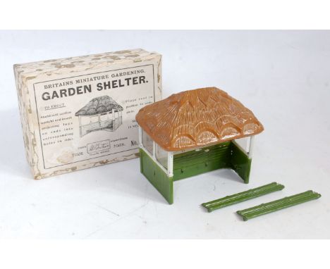 A Britains miniature garden series No. 28 MG Garden Shelter 1930s examples comprising of thatched roof with two green and whi