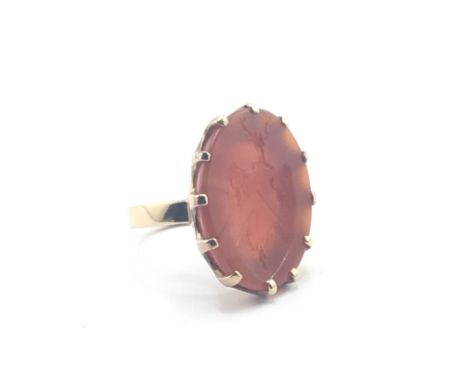 An Intaglio and gold gents seal ring with a family crest in an oval.