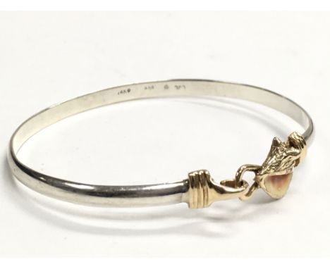 A 14 carat gold and silver bangle , 9.4g. Postage category a