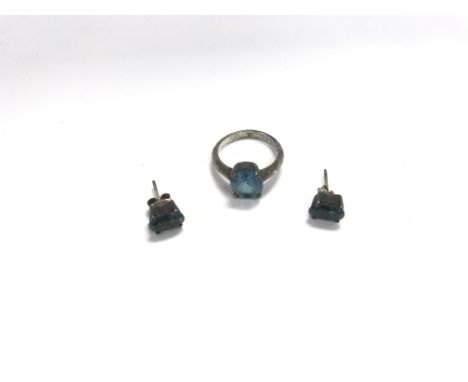 A silver ring and earrings set with blue stones.