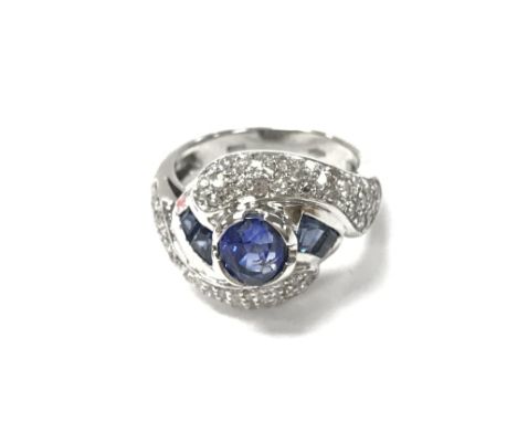 A platinum ring set with sapphires and brilliant cut diamonds. Circa 1950s. Size J and 6.90g.Postage A
