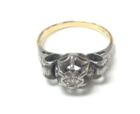 An 18ct gold and platinum ring set with small chip stone diamond. Size O and 4.06g. Postage B