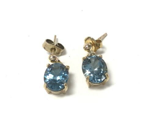 A pair of 9ct gold earrings set with pale blue stones. 4.16g Postage A