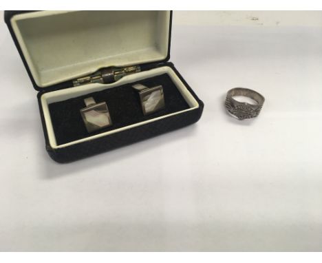 A silver pair of cufflinks and a silver Harley Davidson motorcycles ring.