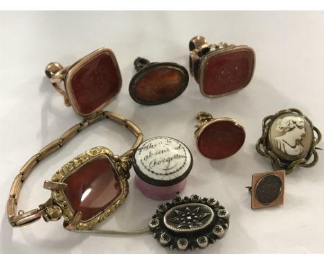 A collection of Georgian and later watch fob seals, together with two brooches and an enamel pill box