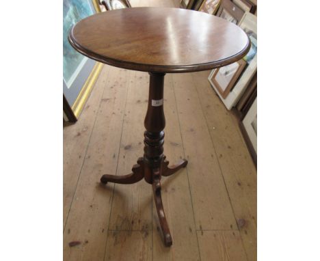 A mahogany circular topped tripod table, raised on a turned column and three outwept supports, diameter 18ins, height 28ins