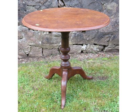 A 19th century oak tripod table, raised on a turned column, with three outswept supports, diameter 24ins, height 26ins