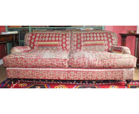 KILIM SOFA, three seater, with turned front supports on brass castors. 186cm W x 94cm D.