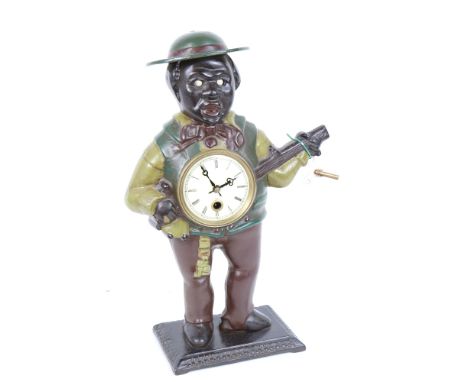 An American painted cast-iron novelty figural clock, modelled as man playing a banjo with moving eyes, height 37cm, with key 