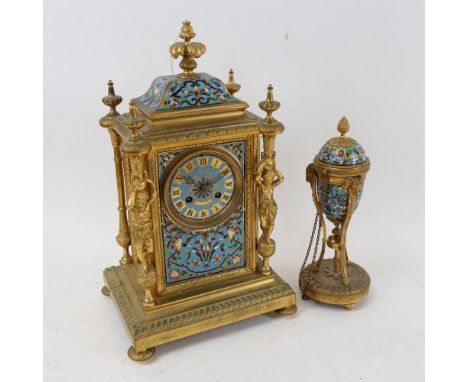An ornate brass mantel clock, with floral decorated enamelled panels, height 35cm, and matching candlestick which converts to