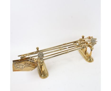 A set of polished brass fire irons on stands, length 67cm, and a toasting fork 