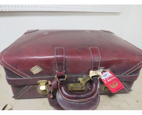 A vintage lined red leather suitcase 
