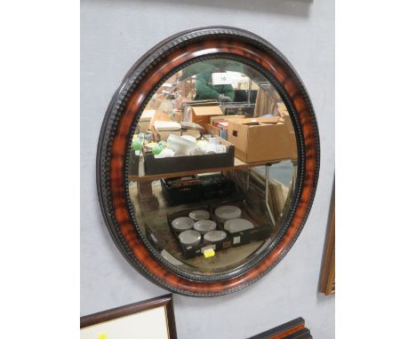 A vintage oval bevelled and framed mirror 