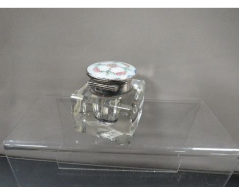 A hallmarked silver and enamel mounted glass desk inkwell, the lid decorated with roses and foliage in a quatrefoil design, m